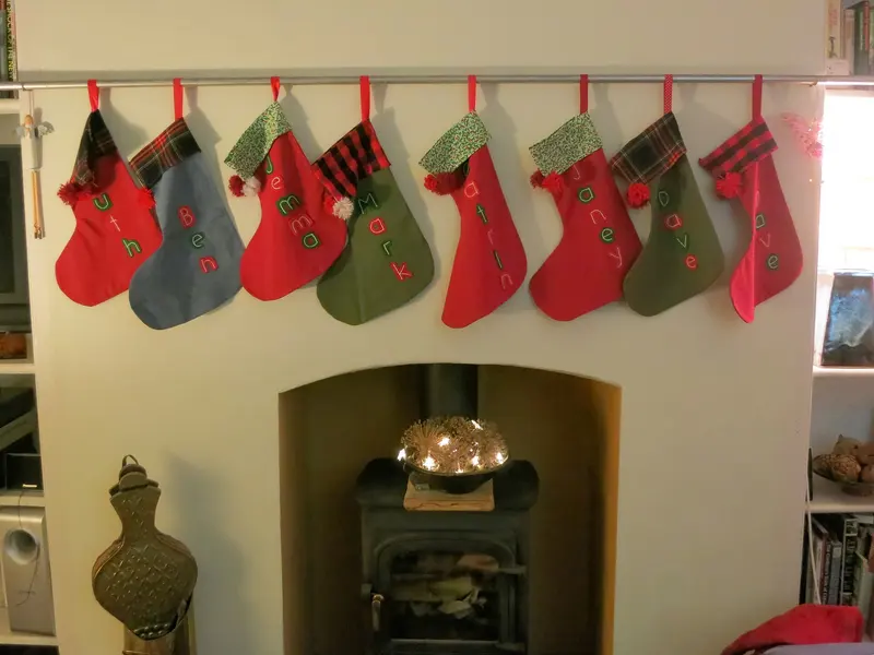 A row of Christmas stockings above a fireplace