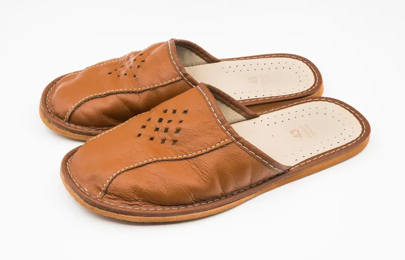 A pair of tan leather mule slippers