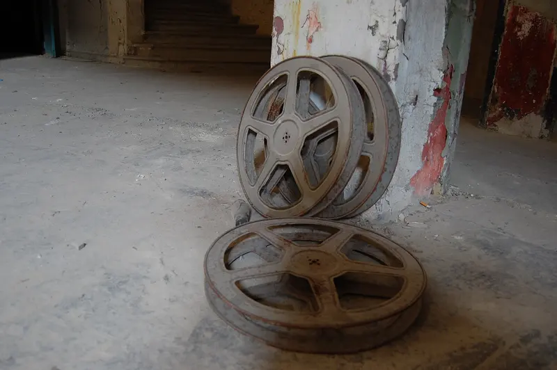 Old metal film reels stacked on a dusty floor